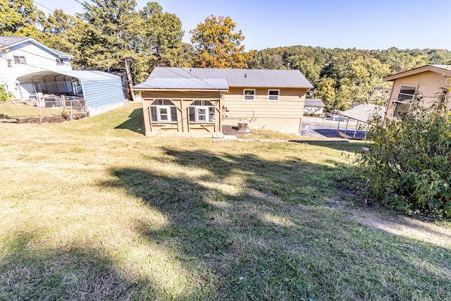 rear view of property with a yard and a carport