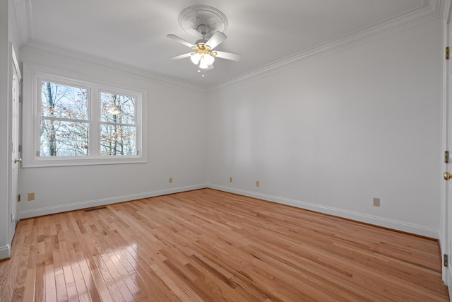 spare room with light wood-style flooring, ornamental molding, and baseboards