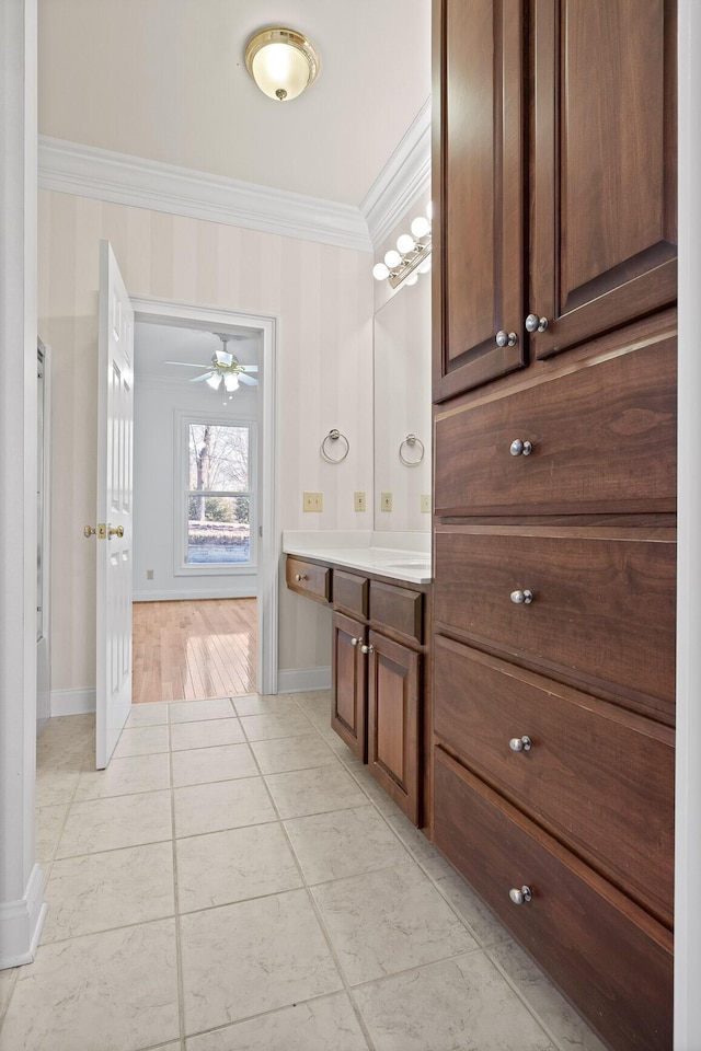 bathroom featuring tile patterned floors, baseboards, ornamental molding, and vanity