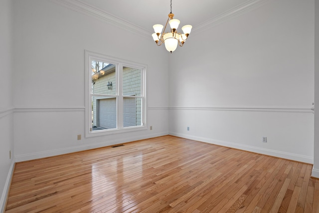 empty room featuring baseboards, light wood finished floors, and crown molding