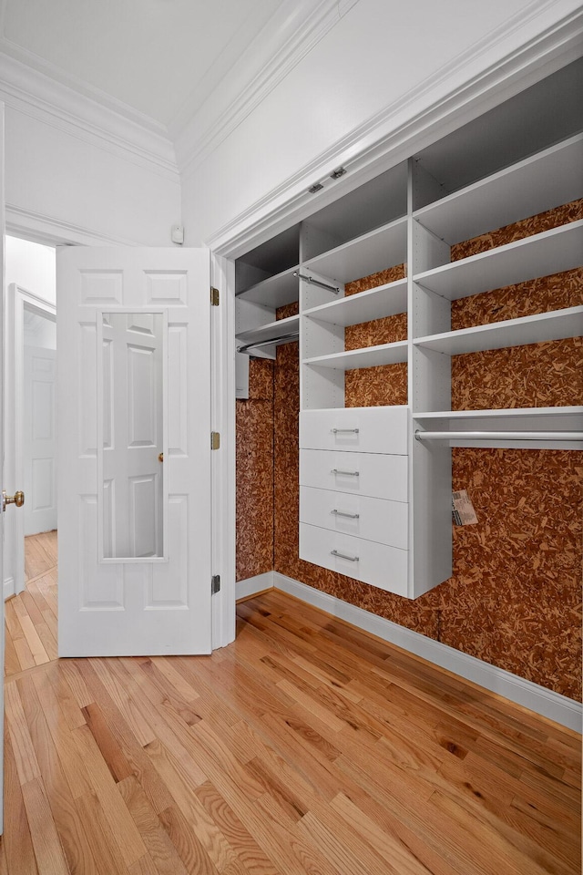 mudroom with light wood-style floors and ornamental molding