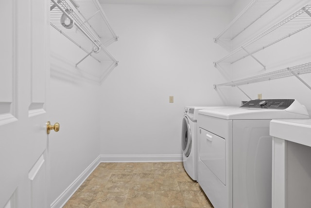 laundry area featuring washing machine and dryer, laundry area, and baseboards