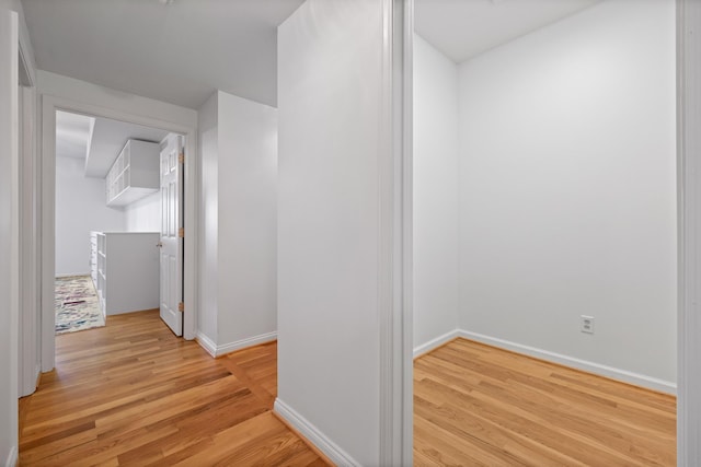 hallway with light wood finished floors and baseboards