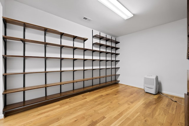 empty room with baseboards, visible vents, and light wood finished floors