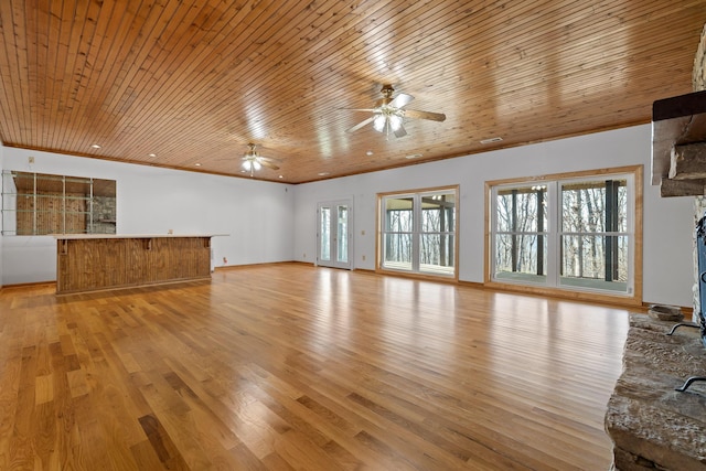 unfurnished living room with ceiling fan, wooden ceiling, light wood-style flooring, baseboards, and ornamental molding