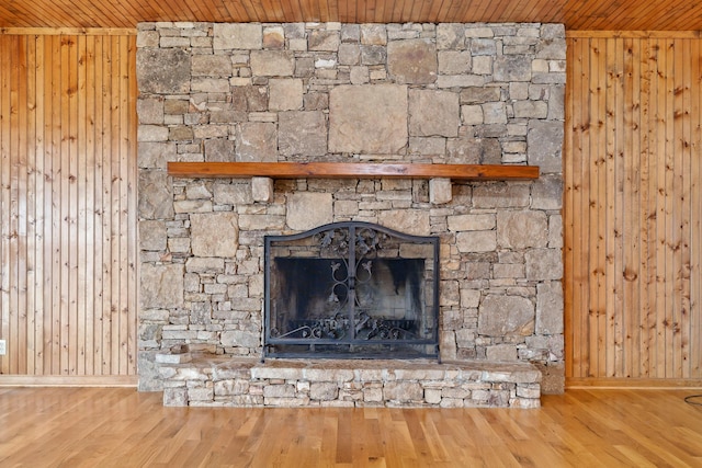 room details with wooden walls, wood ceiling, a fireplace, and wood finished floors