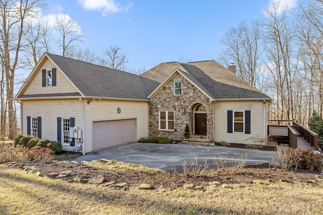 view of front of house featuring aphalt driveway, an attached garage, stone siding, roof with shingles, and a chimney