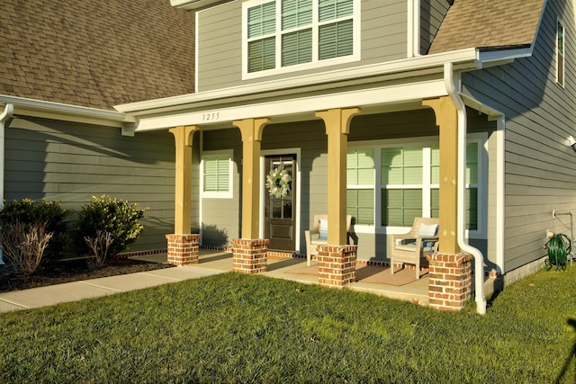 property entrance with a porch and a lawn