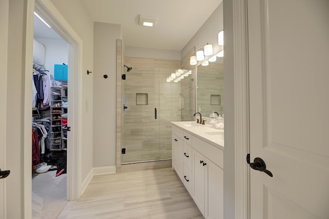 bathroom with vanity, wood-type flooring, and a shower with shower door