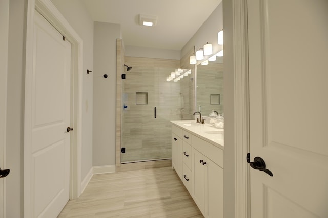 bathroom with vanity, wood-type flooring, and a shower with door