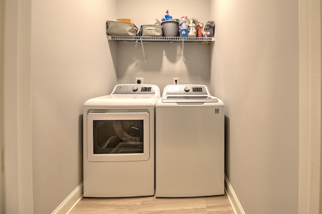 washroom with independent washer and dryer and light hardwood / wood-style flooring