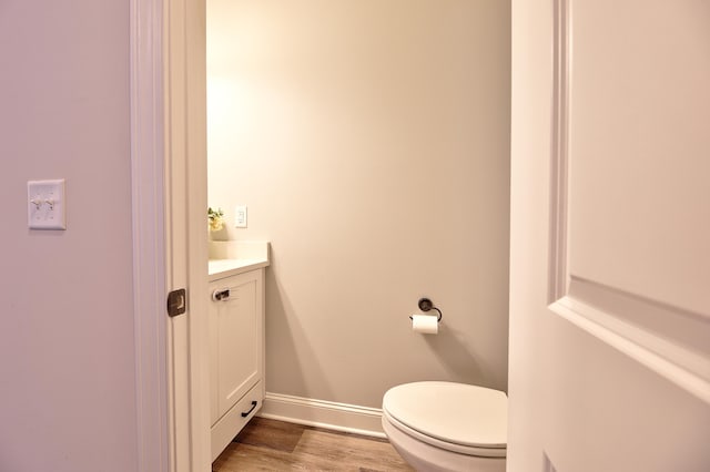 bathroom featuring vanity, hardwood / wood-style flooring, and toilet