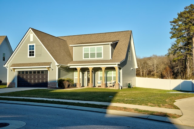 view of front of house with a garage, a front yard, and covered porch