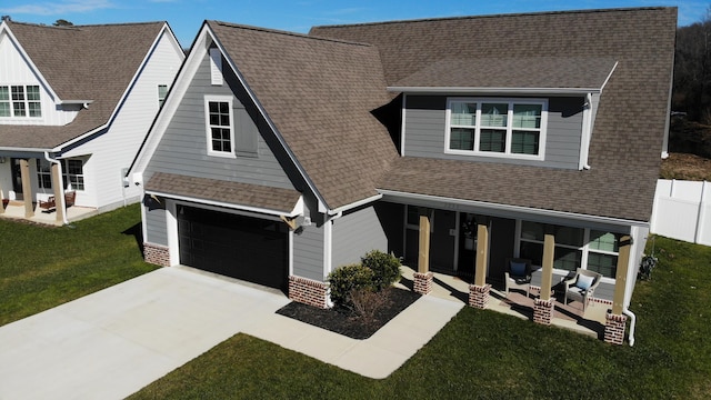 view of front of house with a garage, a front yard, and a patio