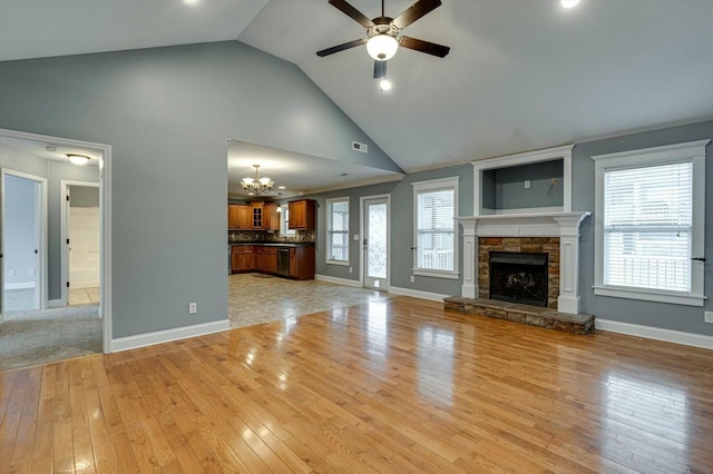 unfurnished living room with a stone fireplace, light hardwood / wood-style floors, and a healthy amount of sunlight