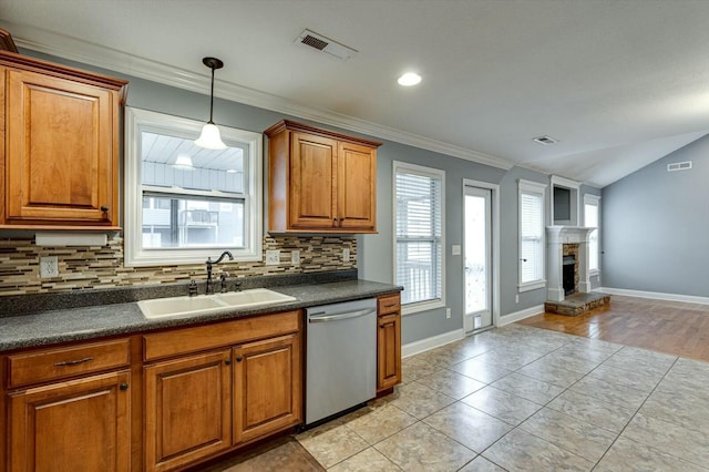 kitchen with stainless steel dishwasher, sink, decorative backsplash, and a wealth of natural light