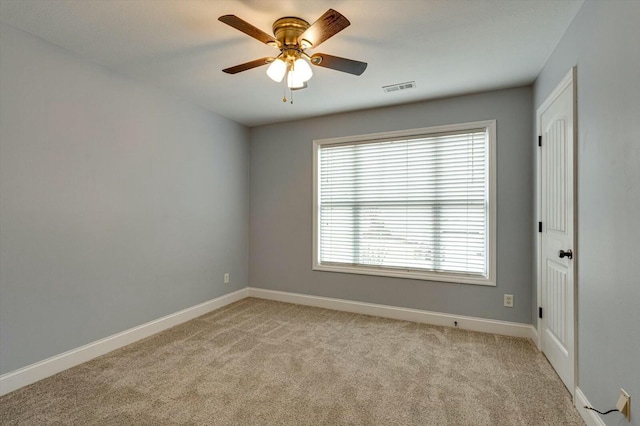 carpeted spare room with ceiling fan