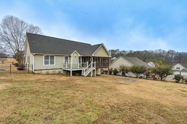 view of front of house with a sunroom, a deck, and a front yard