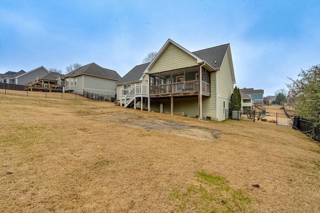 rear view of property featuring a yard and a sunroom