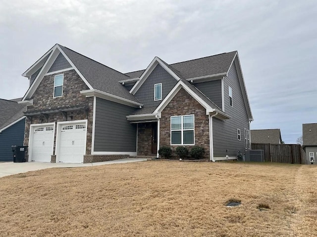 craftsman house with a garage and a front lawn