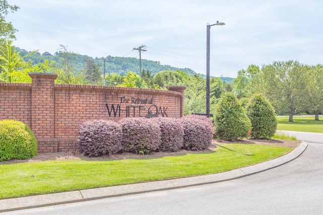 community / neighborhood sign featuring a lawn