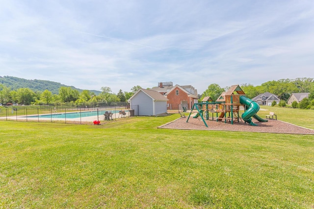 view of play area with a lawn, a fenced in pool, and a mountain view