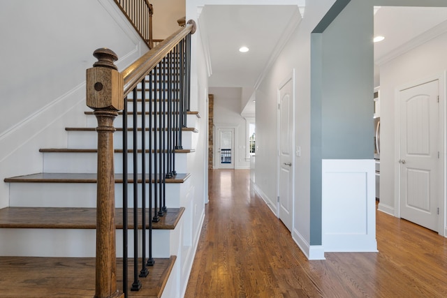 stairs featuring hardwood / wood-style floors and ornamental molding