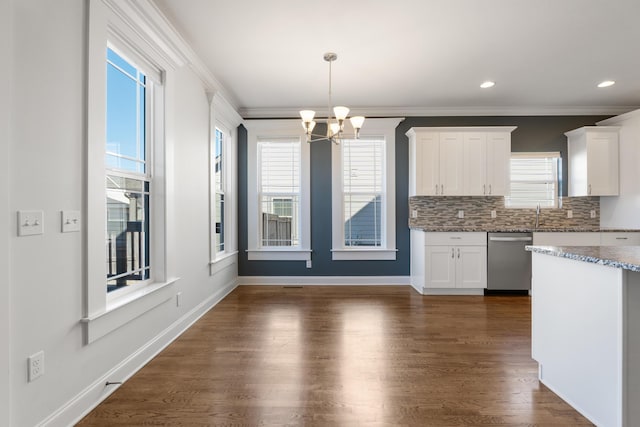 kitchen with white cabinetry, dark wood-type flooring, stainless steel dishwasher, hanging light fixtures, and ornamental molding