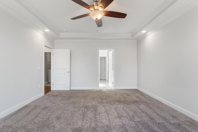 unfurnished bedroom with a tray ceiling, ceiling fan, crown molding, and carpet floors