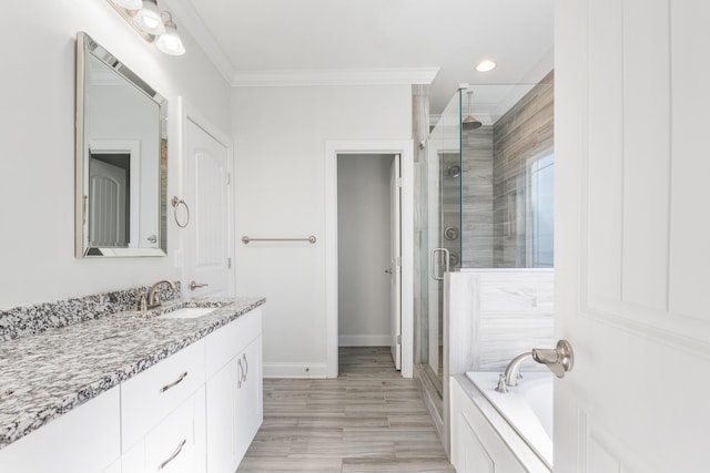 bathroom featuring ornamental molding, vanity, and independent shower and bath