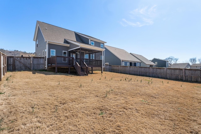 rear view of property with a yard and a wooden deck