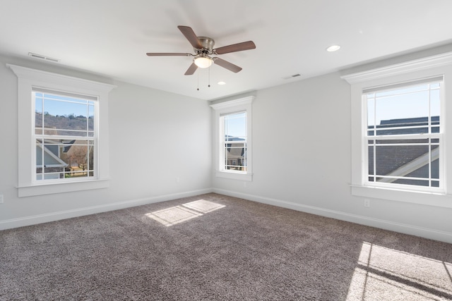 spare room featuring carpet floors, ceiling fan, and plenty of natural light