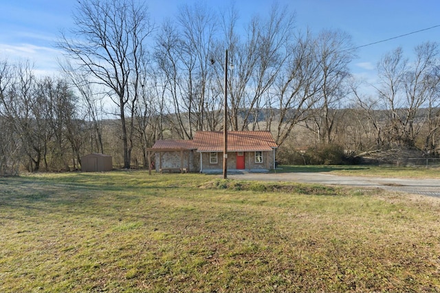 view of front of home featuring a front yard and a storage unit