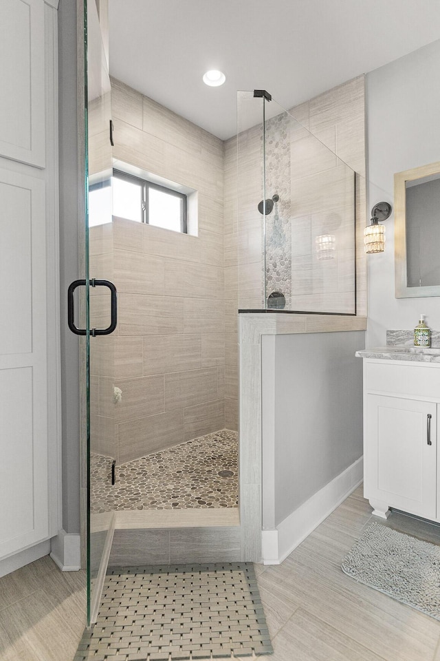 bathroom featuring vanity and a shower with shower door