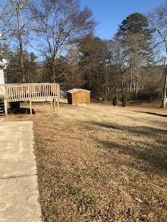 view of yard with a wooden deck and a shed