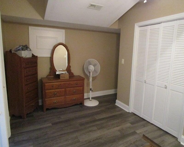 bedroom featuring lofted ceiling, dark hardwood / wood-style floors, and a closet