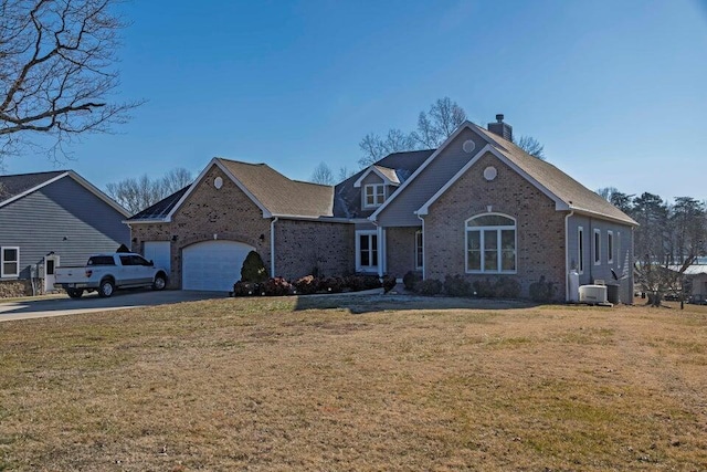 front facade with a garage, a front yard, and central AC unit