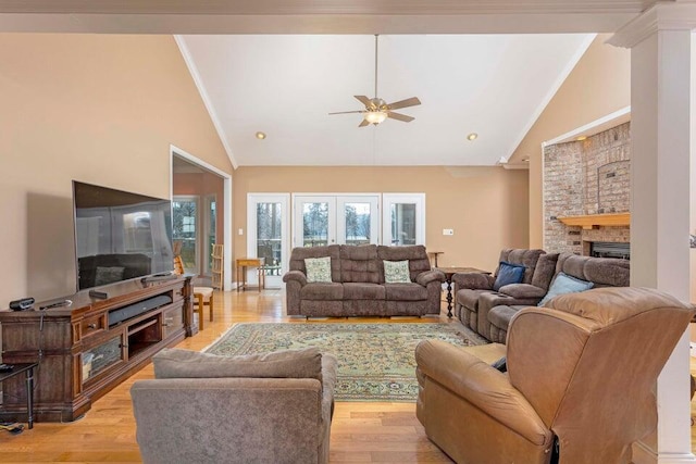 living room with crown molding, high vaulted ceiling, ceiling fan, a fireplace, and light hardwood / wood-style floors