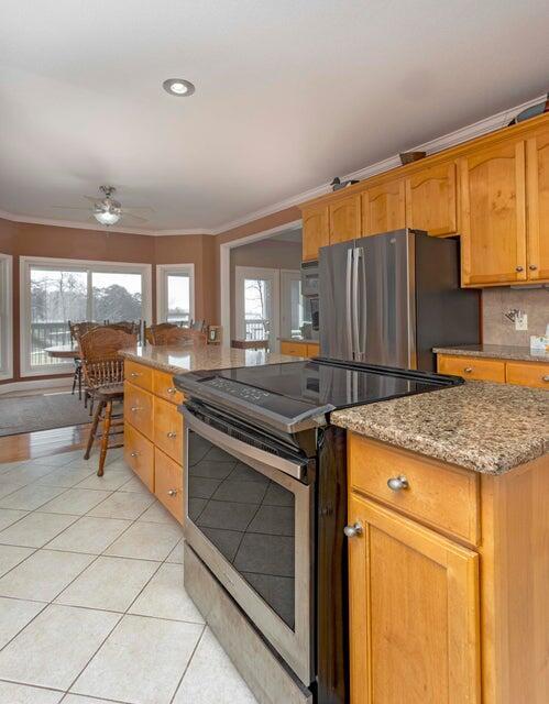 kitchen featuring ornamental molding, appliances with stainless steel finishes, a wealth of natural light, and light tile patterned floors