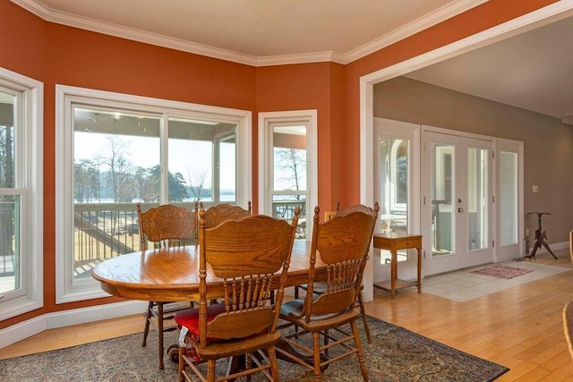 dining room featuring crown molding, light hardwood / wood-style floors, and french doors