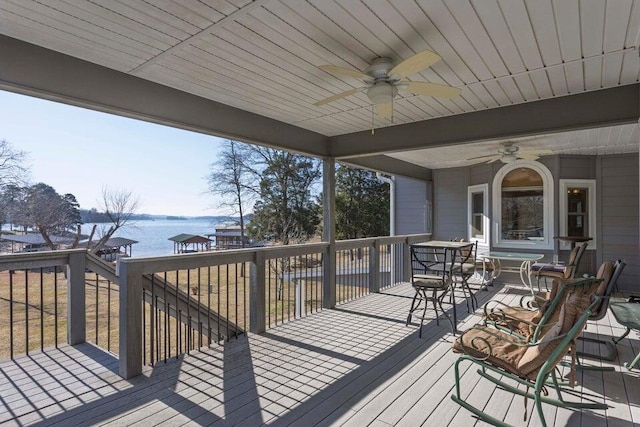 wooden deck featuring ceiling fan and a water view