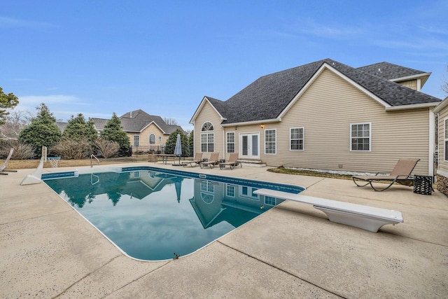 view of pool featuring a diving board and a patio area