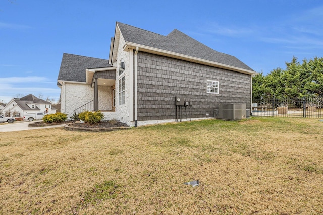 view of property exterior featuring central AC unit and a lawn