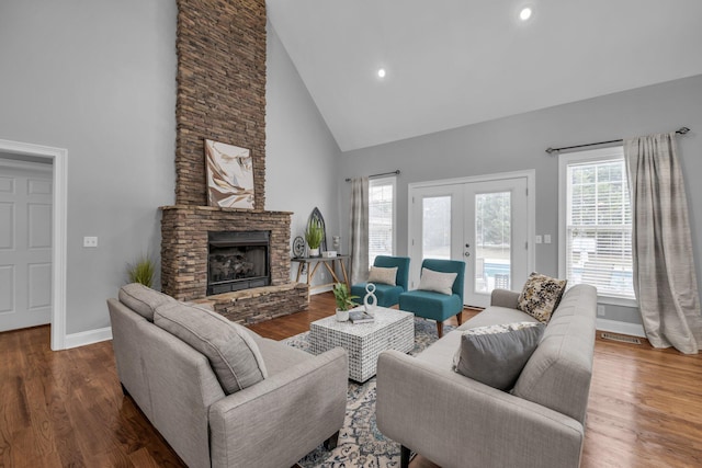 living room featuring french doors, dark hardwood / wood-style flooring, and a stone fireplace