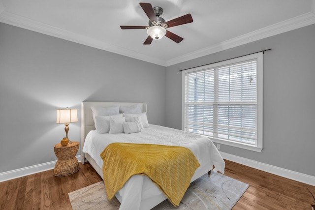 bedroom featuring hardwood / wood-style flooring, ceiling fan, and ornamental molding