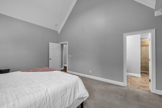 carpeted bedroom with ensuite bathroom and high vaulted ceiling