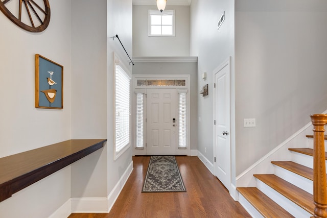 entrance foyer with a towering ceiling and dark hardwood / wood-style flooring