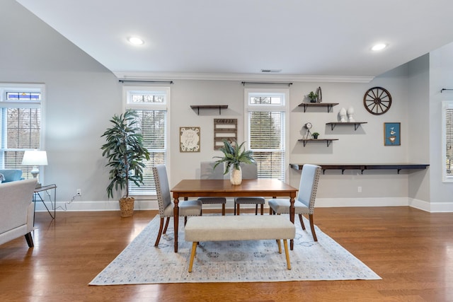 dining space with wood-type flooring and ornamental molding