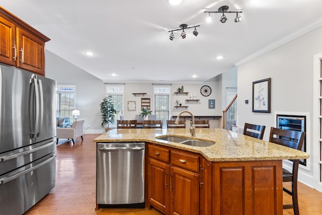 kitchen featuring sink, stainless steel appliances, a kitchen breakfast bar, and a kitchen island with sink