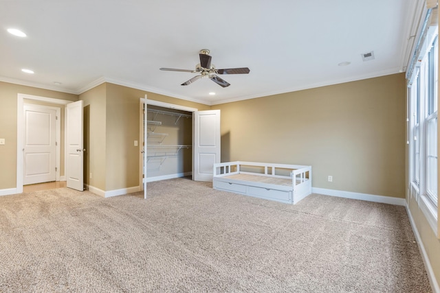 unfurnished bedroom with light carpet, crown molding, a closet, and ceiling fan